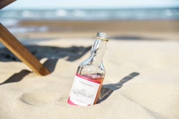 Close-Up Photo of Bottle On Sand