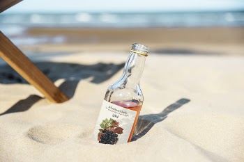 Close-Up Photo of Bottle On Sand