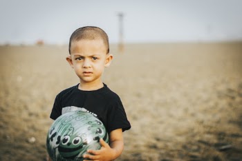 Close-Up Photo of Boy Holding A Ball