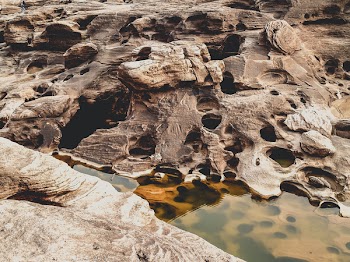 Close-up Photo of Brown rocks Beside Body of Water