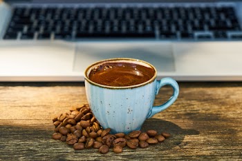 Close-Up Photo of Coffee Cup Beside Coffee Beans