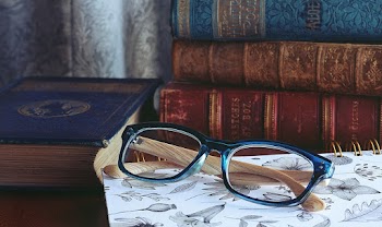 Close-Up Photo of Eyeglasses Near Books