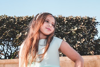 Close-Up Photo of Girl in Gray Top Near Plants Posing