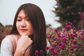 Close-Up Photo of Girl Near Violet Flowers