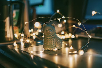 Close-up Photo of Gray Ceramic Cat Figurine Near String Lights