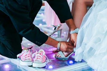 Close-up Photo of Groom Fixing Brides Shoe Strap