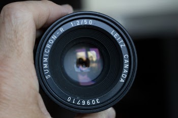 Close-up Photo of Hand Holding Black Camera Lens