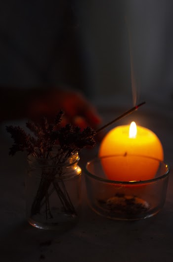 Close-Up Photo of Lighted Incense Stick Near Candle