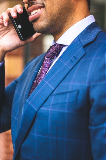 Close-up Photo of Man in Blue Pinstripe Suit Jacket Talking on The Phone