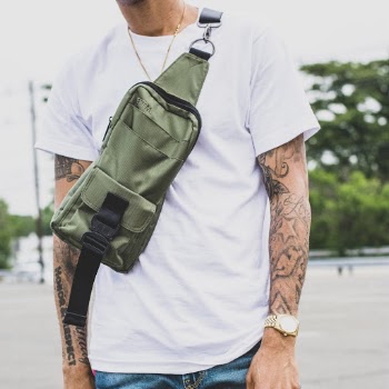 Close-up Photo of Man in White Crew-neck T-shirt and Green Cross body Bag
