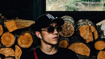 Close-Up Photo Of Man Near Wooden Logs