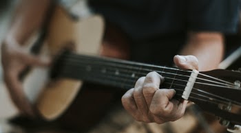 Close-Up Photo of Man Playing Guitar
