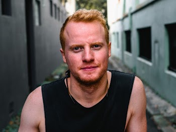 Close-Up Photo of Man Wearing Tank Top Between Buildings