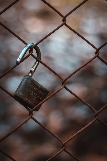 Close-Up Photo Of Padlock Hanging On Chain-link Fence