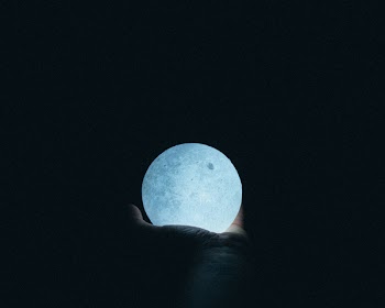 Close-Up Photo Of Person Holding Moon Lamp
