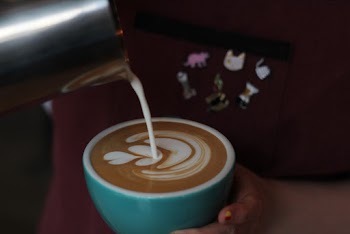 Close-Up Photo of Person Pouring Milk In Coffee