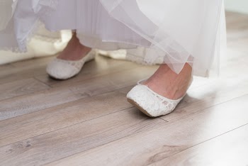Close-Up Photo of Person Wearing White Flat Shoes