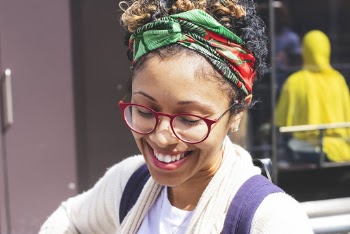 Close-up Photo of Smiling Woman in Red Framed Eyeglasses and Headscarf