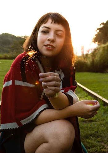 Close-up Photo of Squatting Woman Holding a Sparkler