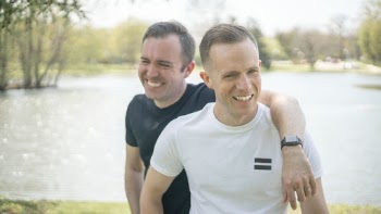 Close-up Photo of Two Friends Standing and Laughing Together
