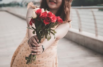 Close-up Photo of White and Red Rose Held by Smiling Woman