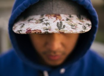 close up photo of white, green, and red floral cap
