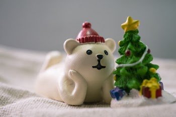 Close-Up Photo of White Polar Bear Beside Christmas Tree Figurines