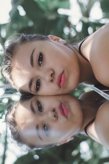 Close-up Photo of Woman's Head Resting on Reflective Surface