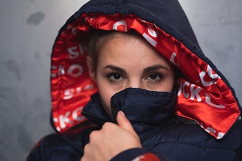 Close-Up Photo of Woman Covering Her Mouth With Her Jacket