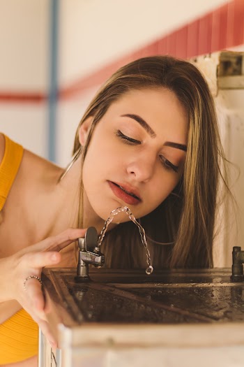 Close-Up Photo of Woman Drinking On Drinking Fountain
