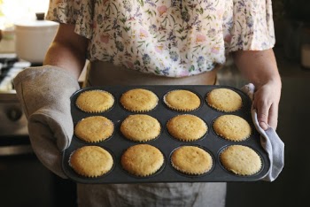 Close-up Photo of Woman Holding Cupcakes in Cupcake Tray