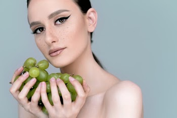 Close-Up Photo of Woman Holding Grapes
