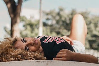 Close-up Photo of Woman in Black Bulls T-shirt Lying on Ground