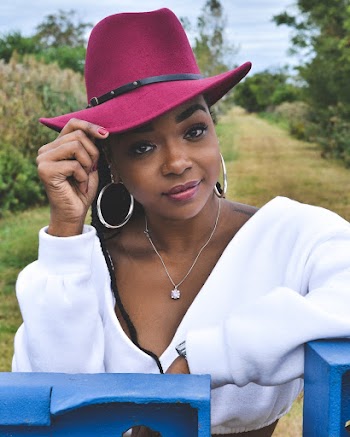Close-up Photo of Woman in Maroon Fedora Hat and White Top Posing