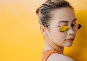 Close-up Photo of Woman in Sunglasses Posing In Front of Yellow Background