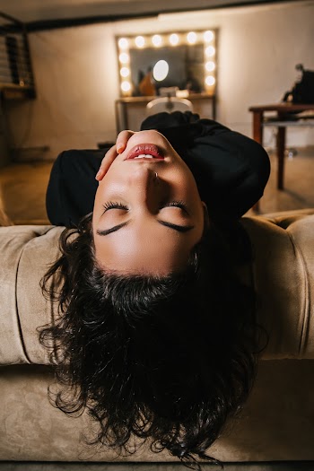 Close-up Photo of Woman Leaning Her Head Backwards on a Sofa With Her Eyes Closed