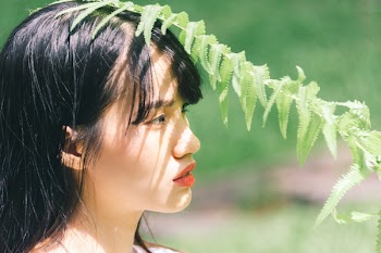 Close-Up Photo Of Woman Near Fern Plant