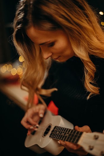 Close-up Photo of Woman Playing Ukulele