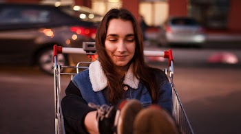 Close-Up Photo of Woman Riding Shopping Cart