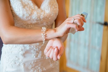 Close-Up Photo of Woman Rubbing Perfume On Her Wrist