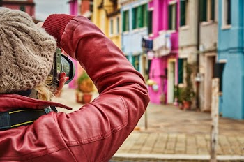 Close-up Photo of Woman Taking Photos of Colorful Houses
