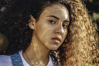 Close-up Photo of Woman with Brown Curly Hair