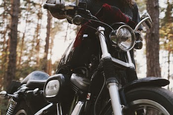 Close-up Photograph of Person Holding Black Motorcycle