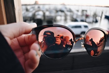 Close-Up Photography of a Person Holding Sunglasses