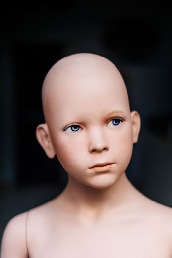 close-up photography of bald doll