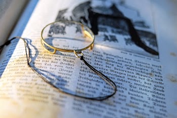 Close-up Photography of Gray Framed Magnifying Glass on Opened Book