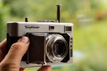 Close-up Photography of Person Holding Gray and Black Film Camera