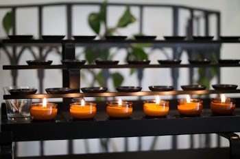 Close Up Photography of Tealight Candles on Black Metal Rack