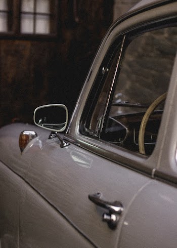 Close-up Photography of White Vehicle Beside Building