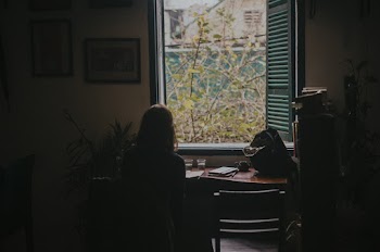 Close-up Photography of Woman Sitting on Chair Watching View of Outside